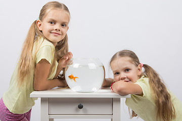 Image showing Two girls have a small fishbowl with goldfish