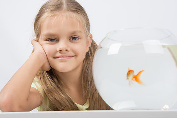 Image showing Happy six year old girl with an aquarium and a goldfish