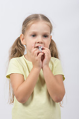 Image showing The little girl eats a chocolate sweet tooth