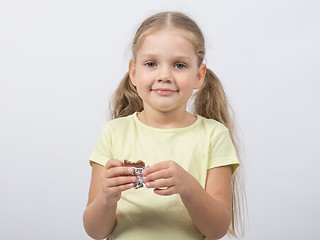 Image showing Portrait of a four-year girl sweet tooth with chocolate in hand