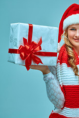 Image showing Girl dressed in santa hat with a Christmas gift 