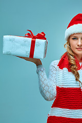 Image showing Girl dressed in santa hat with a Christmas gift 