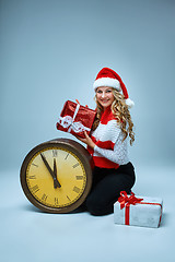 Image showing Girl dressed in santa hat holding with a Christmas decorations  