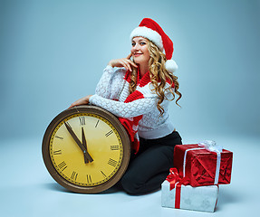 Image showing Girl dressed in santa hat holding with a Christmas decorations  