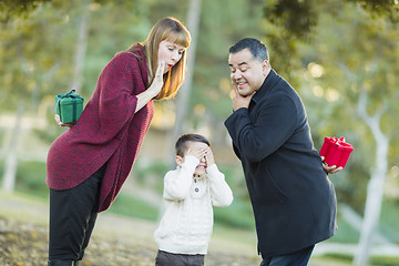 Image showing Mixed Race Parents With Gifts for Young Boy Hiding Eyes