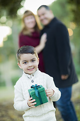Image showing Mixed Race Boy Holding Gift In Front with Parents Behind