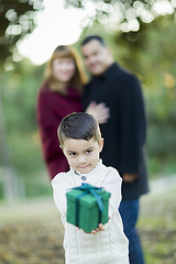 Image showing Mixed Race Boy Holding Gift In Front with Parents Behind