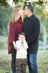 Image showing Mix Race Couple Kissing As Young Son Hides His Eyes