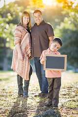 Image showing Mixed Race Couple Stands Behind Son with Blank Chalk Board