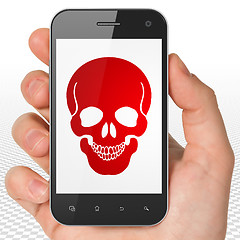 Image showing Medicine concept: Hand Holding Smartphone with Scull on display