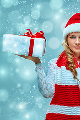 Image showing Girl dressed in santa hat with a Christmas gift 