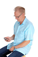 Image showing Older man looking at his cell phone.