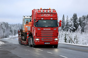 Image showing Red Scania R500 Hauls Daewoo Excavator on Winter Road