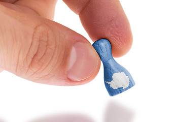 Image showing Hand holding wooden pawn, flag painting, selective focus