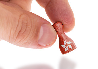 Image showing Hand holding wooden pawn, flag painting, selective focus