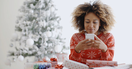 Image showing Young African woman checking for Xmas messages