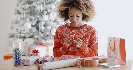 Image showing Happy young African woman wrapping presents