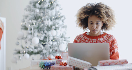 Image showing Young woman using a laptop at Christmas