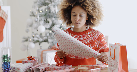 Image showing Happy young African woman wrapping presents