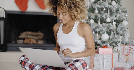 Image showing Pretty young student in front of a Christmas tree