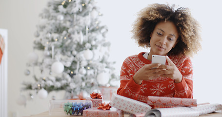 Image showing Young African woman checking for Xmas messages