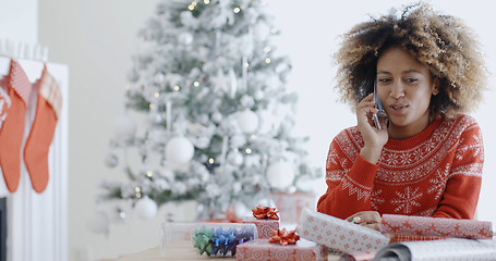 Image showing Young African woman wrapping gifts at Christmas