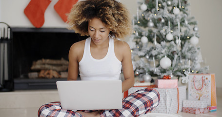 Image showing Woman using a laptop in front of the Xmas tree