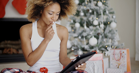 Image showing Thoughtful woman catching up on Christmas news