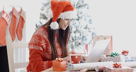 Image showing Smiling young woman surfing for Christmas bargains