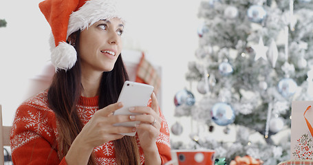 Image showing Attractive woman checking for Christmas messages