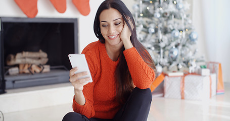 Image showing Young woman checking out her text messages