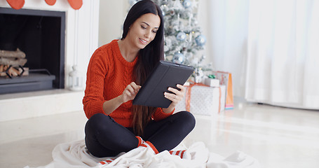 Image showing Smiling woman catching up on her social media