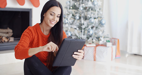 Image showing Smiling woman catching up on her social media