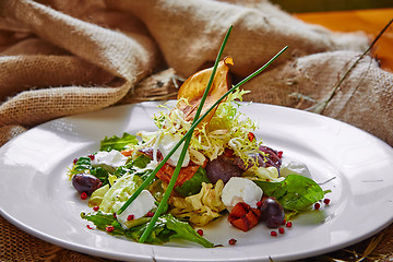 Image showing Fresh spring salad with feta cheese, red onion in white bowl. 