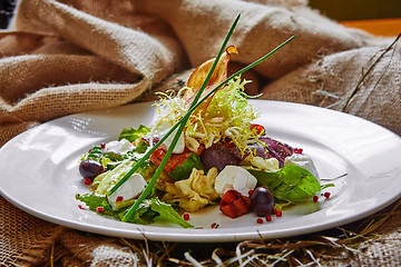 Image showing Fresh spring salad with feta cheese, red onion in white bowl. 