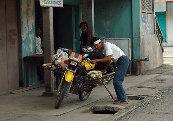 Image showing Asian man with motorbike.