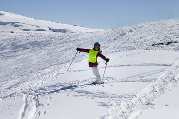 Image showing Little skier on ski slope with new fallen snow at sun day
