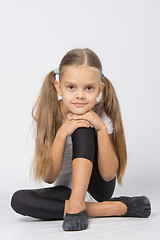 Image showing Girl gymnast sitting on the floor with his pen on his knee