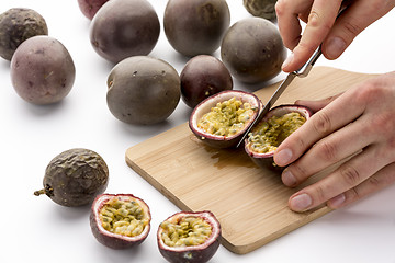 Image showing Halving Passion Fruits With A Kitchen Knife