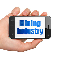 Image showing Industry concept: Hand Holding Smartphone with Mining Industry on display