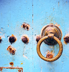 Image showing rusty metal   nail dirty stripped paint in the blue wood door an