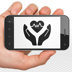 Image showing Insurance concept: Hand Holding Smartphone with Heart And Palm on display