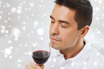 Image showing happy man drinking red wine from glass at home