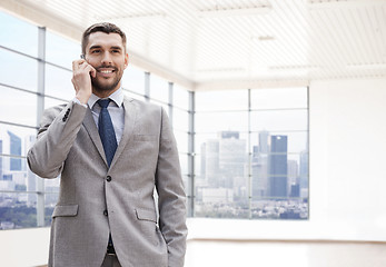 Image showing happy young businessman calling on smartphone