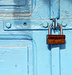 Image showing rusty metal     nail dirty stripped paint in the blue wood door 