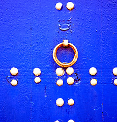 Image showing rusty metal     nail dirty stripped paint in the blue wood door 