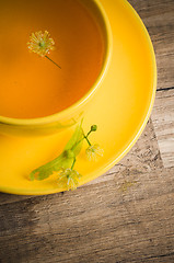 Image showing Yellow cup with linden tea on the table