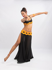 Image showing Young girl mulatto dancing in a long black dress candid