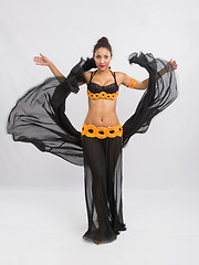 Image showing Young girl mulatto dancing in a long black dress candid