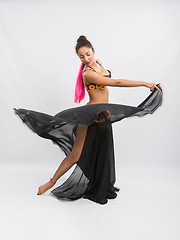 Image showing Young girl mulatto dancing in a long black dress candid